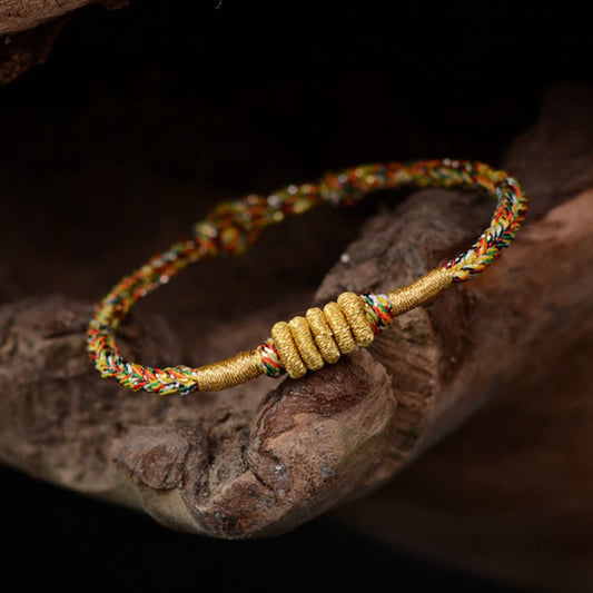 Bracelet tressé de protection traditionnel tibétain ancien, orné d'un nœud King Kong coloré et fait main, selon la tradition du fil rouge bouddhiste.