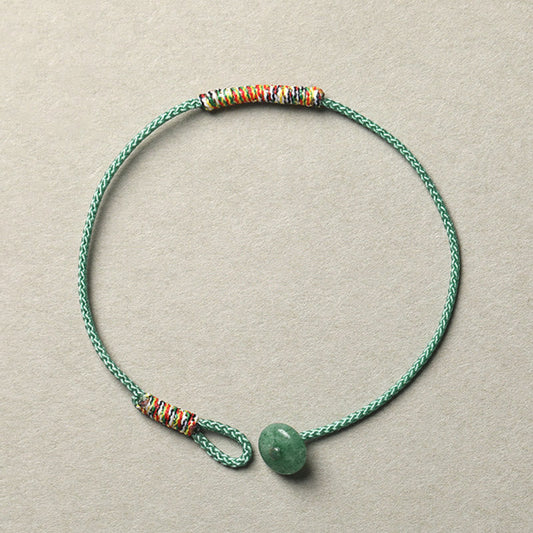 Antikes tibetisch-buddhistisches Armband aus rotem Seil mit grünem Aventurin – ein handgefertigtes Armband zum Schutz vor Glück.