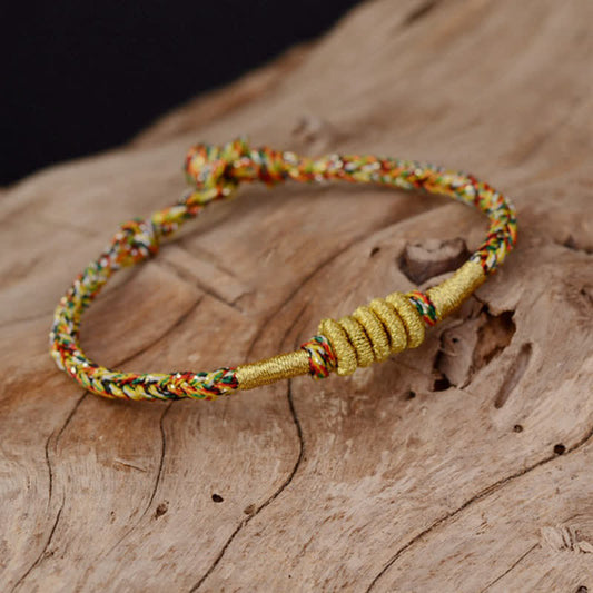 Bracelet tressé de protection traditionnel tibétain ancien, orné d'un nœud King Kong coloré et fait main, selon la tradition du fil rouge bouddhiste.