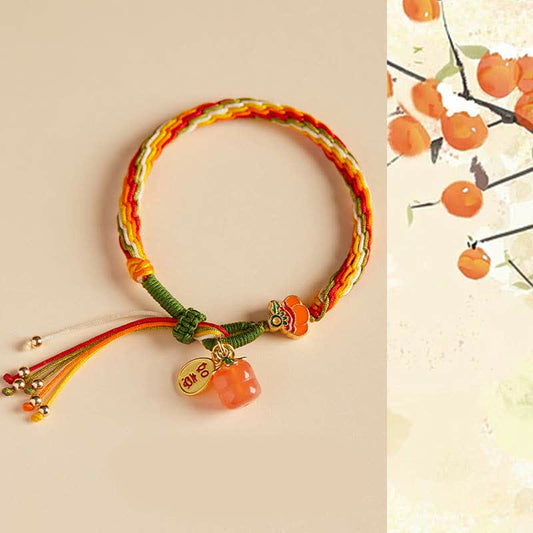 Altes tibetisch-buddhistisches Armband aus rotem Faden mit Kaki-Achat, geflochten, symbolisiert Stärke und Wiedergeburt.
