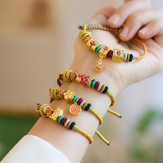 Alte tibetisch-buddhistische Tradition: Geflochtenes Armband mit roter Schnur, Symbol für das Jahr des Drachen, Koi-Karpfen, Mahjong-Würfel, Pfirsichblüten und Kupfermünzen.