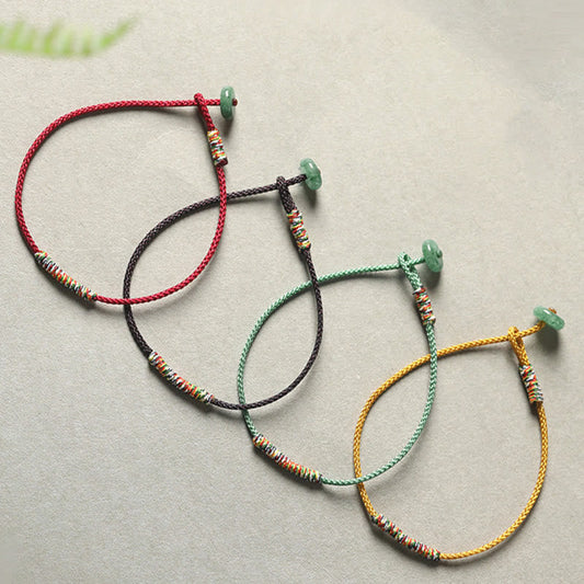 Antikes tibetisch-buddhistisches Armband aus rotem Seil mit grünem Aventurin – ein handgefertigtes Armband zum Schutz vor Glück.