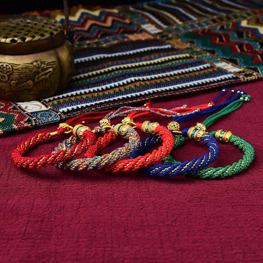Bracelet tibétain traditionnel bouddhiste ancien à cordes rouges, orné d'un Thangka porte-bonheur fait main, avec breloque roue de prière et fil rouge.