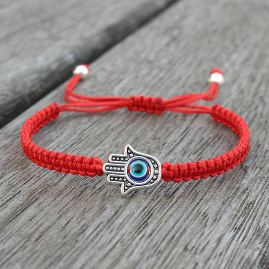 Alte tibetisch-buddhistische Tradition: Handgefertigtes Armband mit rotem Faden und Hamsa-Symbol zum Schutz und Glücksbringen