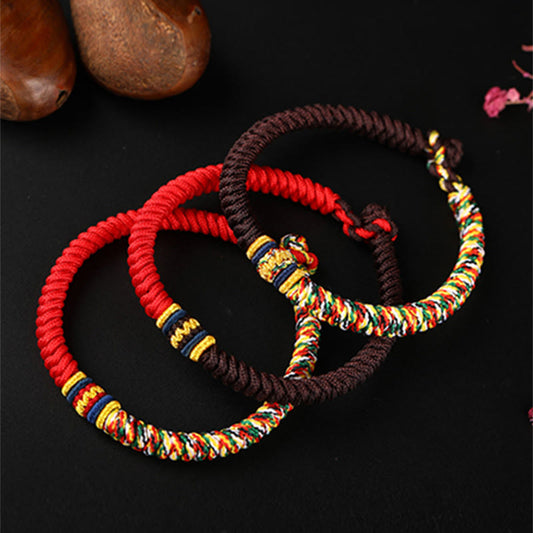 Bracelet tibétain traditionnel en corde rouge, tressé à la main avec un nœud King Kong multicolore, selon la tradition du bouddhisme tibétain ancien.