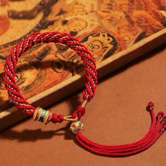 Bracelet tibétain traditionnel bouddhiste ancien à cordes rouges, orné d'un Thangka porte-bonheur fait main, avec breloque roue de prière et fil rouge.