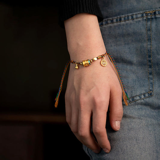 Bracelet traditionnel tibétain ancien en corde rouge, inspiré de la tradition du moulin à prières Om Mani Padme Hum, fait main.