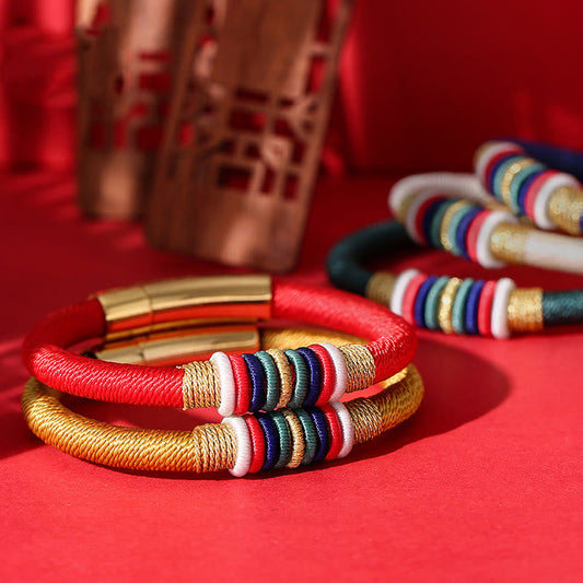 Alte tibetisch-buddhistische Tradition: Handgefertigtes, farbenfrohes Armband mit rotem Faden und King-Kong-Knoten – Symbol der fünf Elemente und des Glücks.