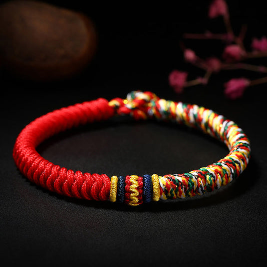 Bracelet tibétain traditionnel en corde rouge, tressé à la main avec un nœud King Kong multicolore, selon la tradition du bouddhisme tibétain ancien.