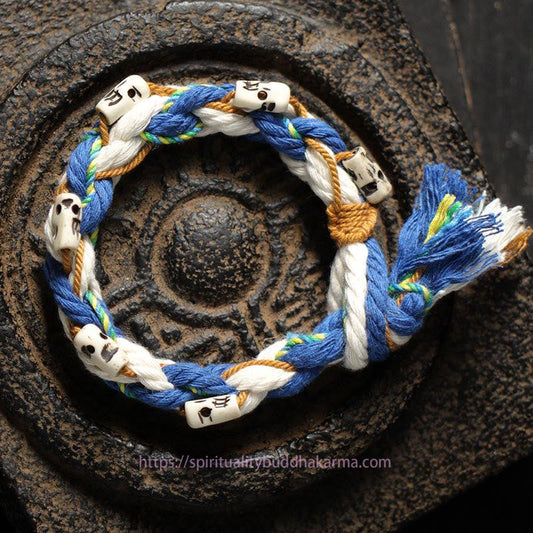 Bracelet porte-bonheur tibétain traditionnel à perles rouges, orné d'une perle gravée à la main, représentant la déesse de la richesse Zakiram.