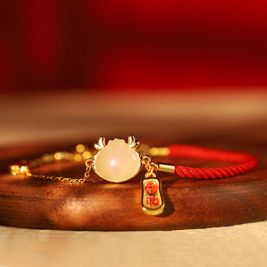 Armband aus 925er Sterlingsilber mit roter Schnur, inspiriert vom Jahr des Drachen und dem Motiv eines chinesischen Dampfbrötchens, symbolisiert Glück und Segen.