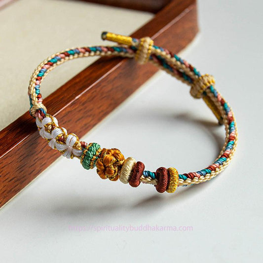 Alte tibetisch-buddhistische Tradition: Handgefertigtes Armband aus rotem Faden in Dunhuang-Farben mit Pfirsichblütenmuster 