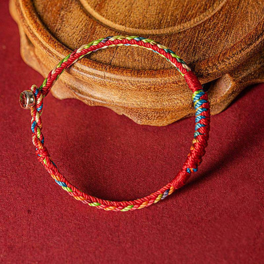 Bracelet de protection fait main selon la tradition bouddhiste tibétaine ancienne du fil rouge et cinq couleurs