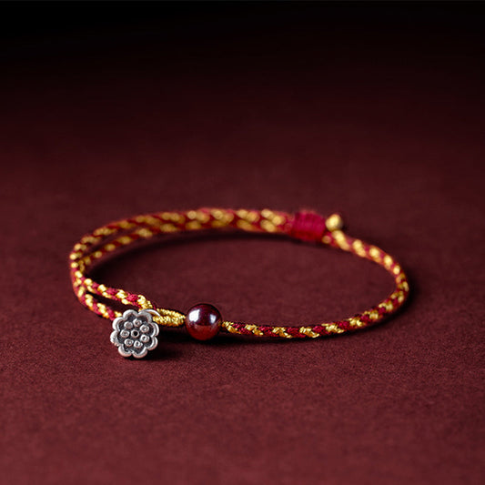 Antikes tibetisch-buddhistisches Armband aus rotem Seil mit Lotus-Anhänger und Friedenssymbolen aus Rotgold, handgefertigt nach roter und goldener Seiltradition. 