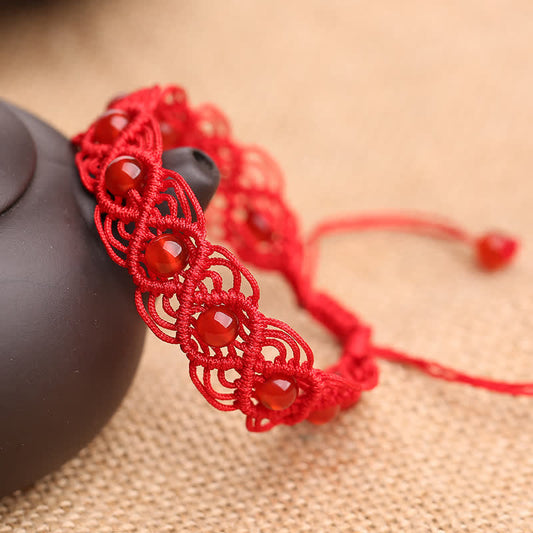 Bracelet en agate rouge, symbole de spiritualité, de karma et de confiance, avec un fil rouge. 