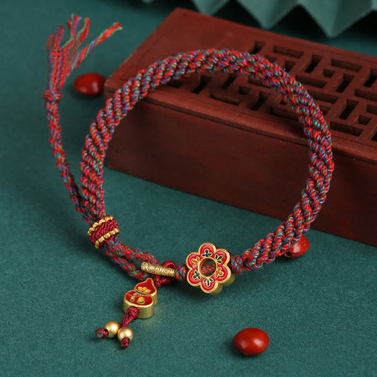 Alte tibetisch-buddhistische Tradition: Handgefertigtes, farbenfrohes Armband aus geflochtener Schnur mit Kürbisblütenmotiv zum Schutz vor roten Fäden