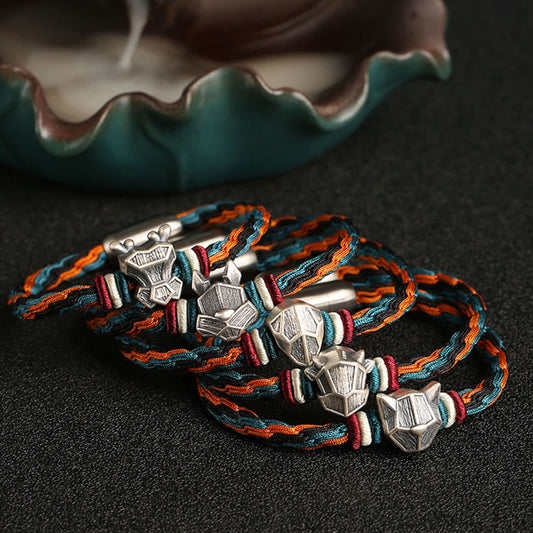Antikes tibetisch-buddhistisches Armband aus rotem Seil, handgefertigt aus 999er Sterlingsilber, zum Schutz des chinesischen Tierkreiszeichens Drache und mit dem Symbol der Wiedergeburt. 