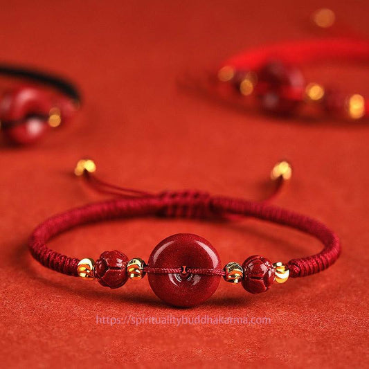 Bracelet tressé de bénédiction, orné d'une boucle en cinabre et d'un fil rouge, selon la tradition bouddhiste tibétaine ancienne.