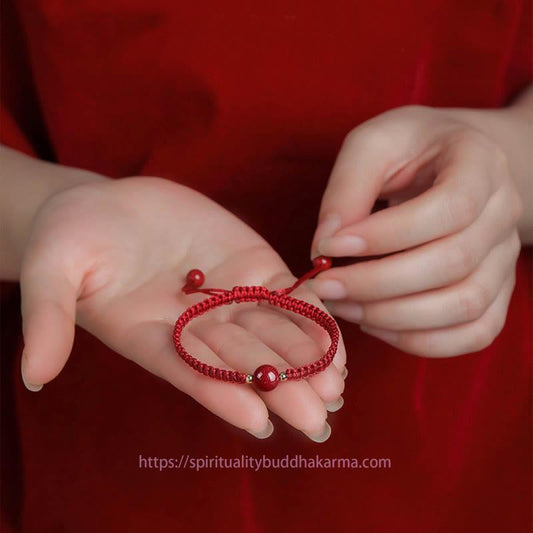 Bracelet de perles de cinabre porte-bonheur, symbole de la tradition bouddhiste tibétaine ancestrale du fil rouge