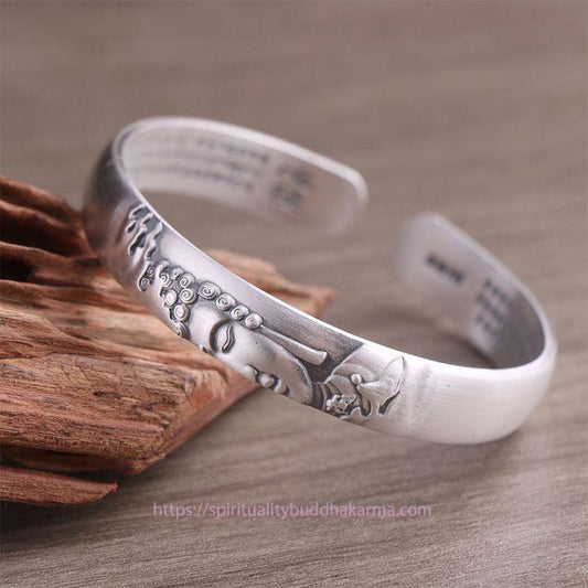Bracelet jonc en argent sterling 999 représentant la tête de Bouddha et le Sutra du Cœur, symbole de spiritualité et de sérénité.