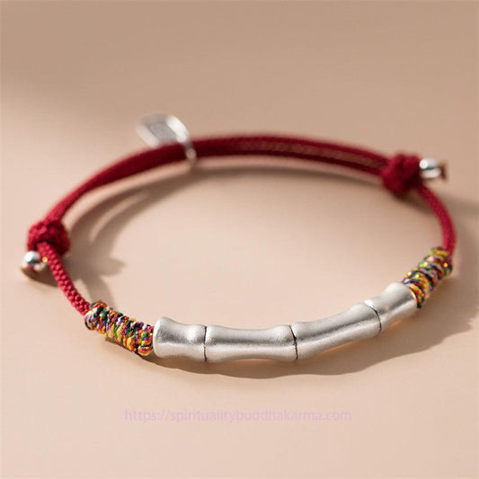 Bracelet en corde rouge colorée, symbole de chance et de prospérité, porté selon la tradition bouddhiste tibétaine ancestrale. Argent sterling 999, bambou et corde rouge.