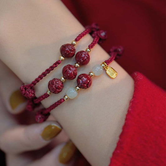 Armband aus der alten tibetisch-buddhistischen Tradition mit rotem Faden, gefertigt aus Zinnober, Jade und Lotusblüten.