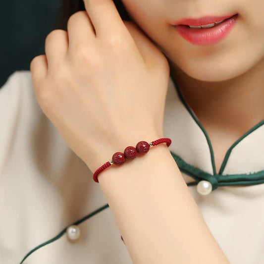 Bracelet tressé traditionnel tibétain bouddhiste à la corde rouge, fait main, en cinabre, orné de perles gravées Om Mani Padme Hum et portant la tradition du fil rouge. 