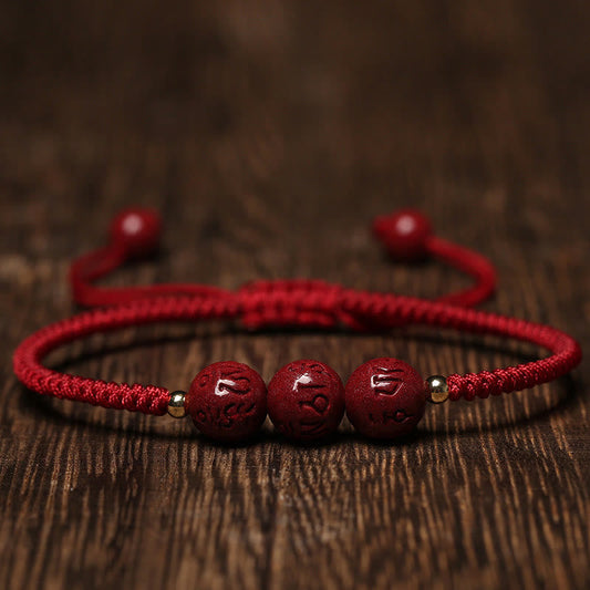 Bracelet tressé traditionnel tibétain bouddhiste à la corde rouge, fait main, en cinabre, orné de perles gravées Om Mani Padme Hum et portant la tradition du fil rouge. 