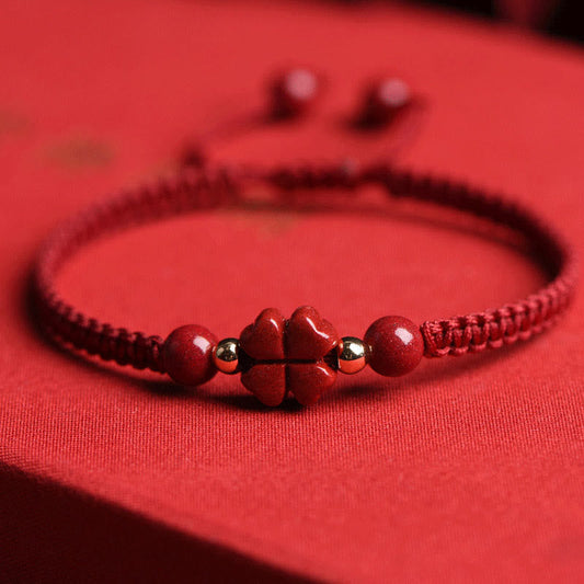 Bracelet de cordon rouge, symbole de bénédiction du cinabre, trèfle à quatre feuilles et fleur à cinq pétales, tradition bouddhiste tibétaine ancienne.