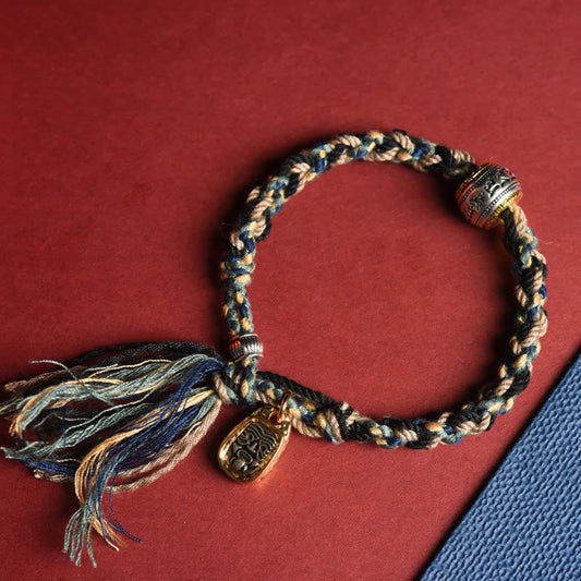 Bracelet artisanal traditionnel tibétain à la corde rouge, symbole de Zakiram, déesse de la richesse, Om Mani Padme Hum et de la paix. 