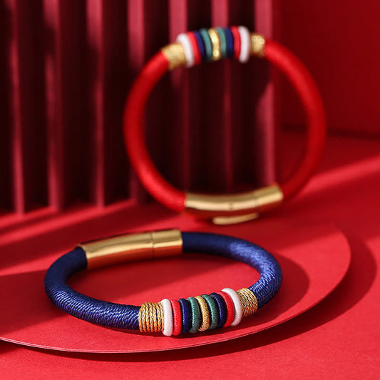 Alte tibetisch-buddhistische Tradition: Handgefertigtes, farbenfrohes Armband mit rotem Faden und King-Kong-Knoten – Symbol der fünf Elemente und des Glücks.