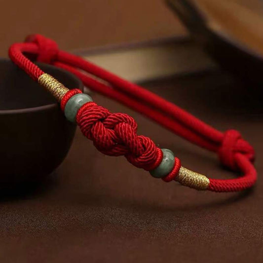 Alte tibetisch-buddhistische Tradition: Armband aus rotem Faden und Jade mit Glücksknoten