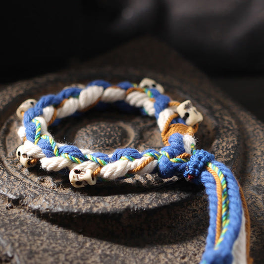 Bracelet porte-bonheur tibétain traditionnel à perles rouges, orné d'une perle gravée à la main, représentant la déesse de la richesse Zakiram.