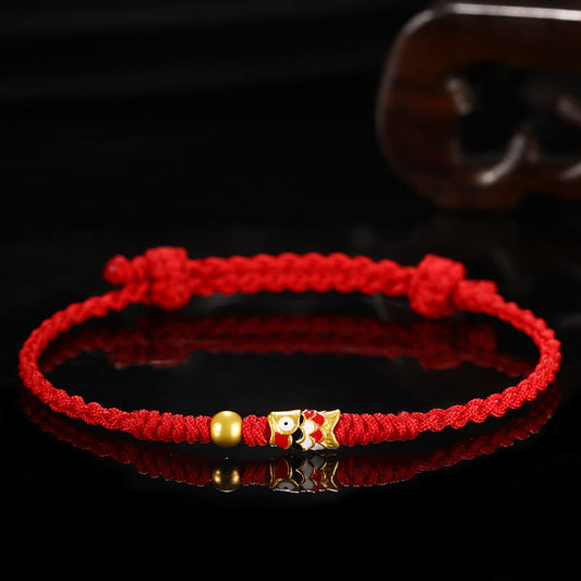 Bracelet tressé artisanal en or 999, symbole de chance, orné d'un poisson koi et inspiré de la tradition bouddhiste tibétaine ancestrale du fil rouge.