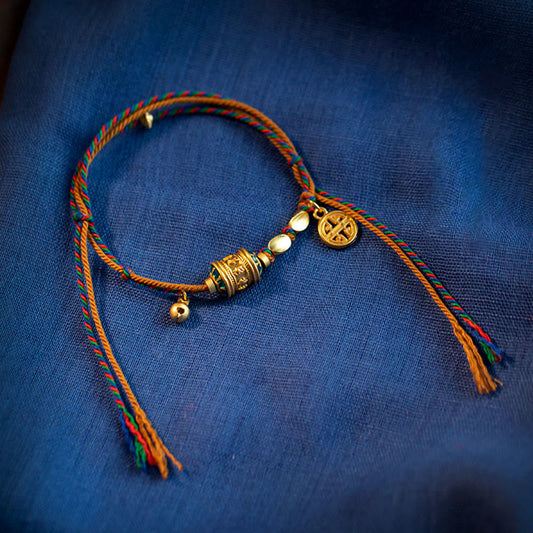 Bracelet traditionnel tibétain ancien en corde rouge, inspiré de la tradition du moulin à prières Om Mani Padme Hum, fait main. 