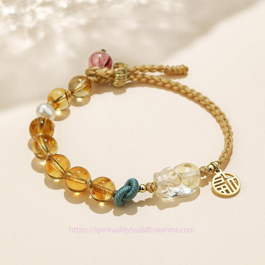 Bracelet tressé en citrine dorée, symbole de richesse et d'énergie, pour le chakra du plexus solaire (troisième chakra) et représentant le caractère PiXiu Fu de la prospérité.