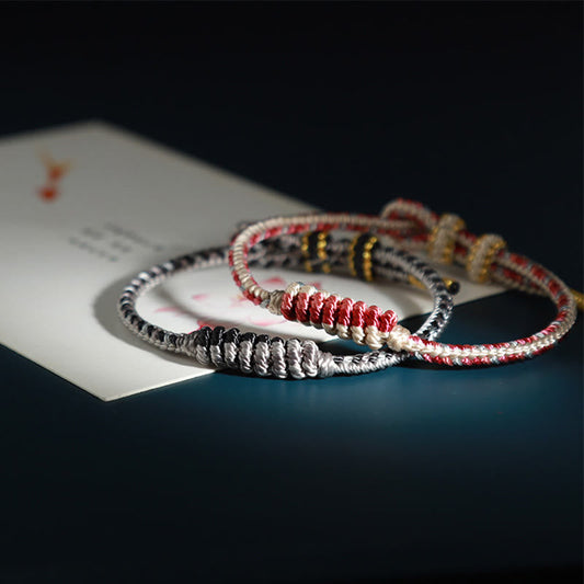 Altes tibetisches buddhistisches Armband mit rotem Faden, handgefertigt mit acht Fäden, Friedensknoten und Gebetsrad-Motiv. 