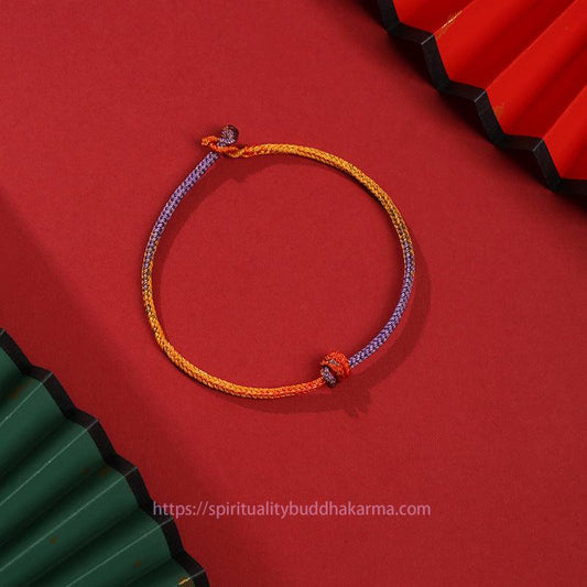 Alte tibetisch-buddhistische Tradition: Handgefertigtes, farbenfrohes Armband aus geflochtenem Seil in Lila, Gold und Rot 