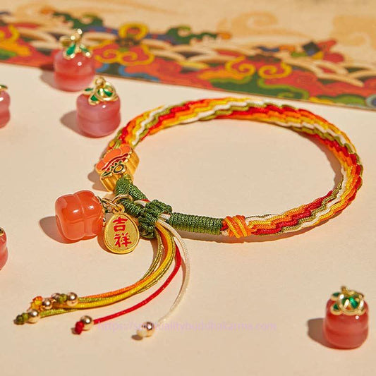 Altes tibetisch-buddhistisches Armband aus rotem Faden mit Kaki-Achat, geflochten, symbolisiert Stärke und Wiedergeburt. 