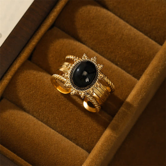 Bague de force en acier titane plaqué or 18 carats, ornée d'obsidienne noire et symbolisant la spiritualité et le karma, inspirée par Bouddha.